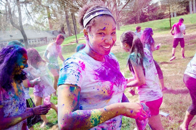 Student is covered in colorful powders during Holi celebrations