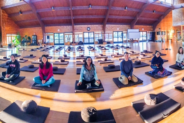 Students sit on meditation cushions