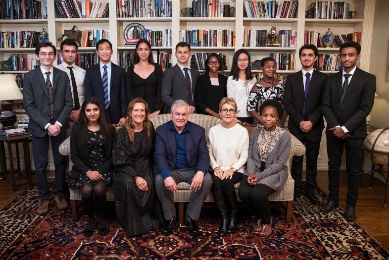 Alvarez family poses with students in front of bookshelves