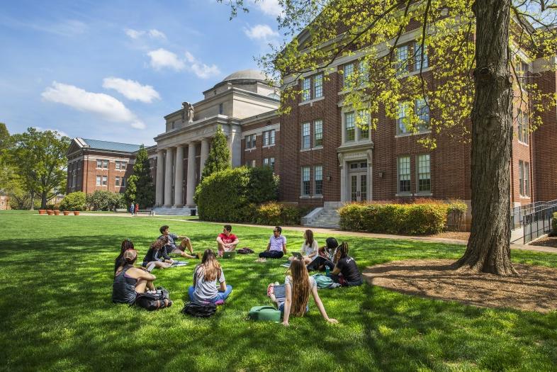 Class group sits in a circle on beautiful day on Chambers lawn