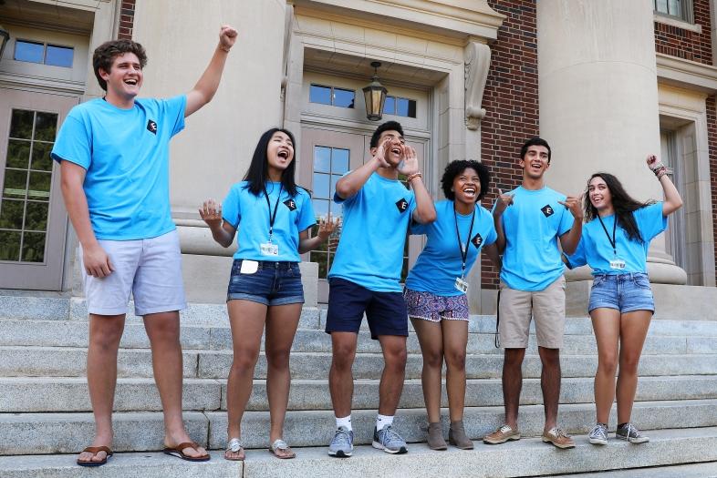 Students in July Experience shirts cheer on the steps of Chambers