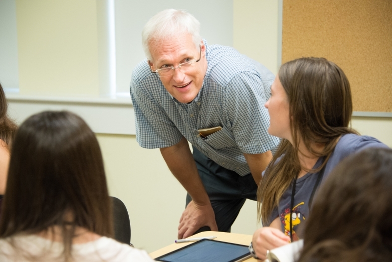 Burkhard Henke talks to student during class