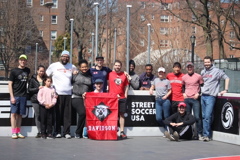 Alumni Group pose holding Davidson flag