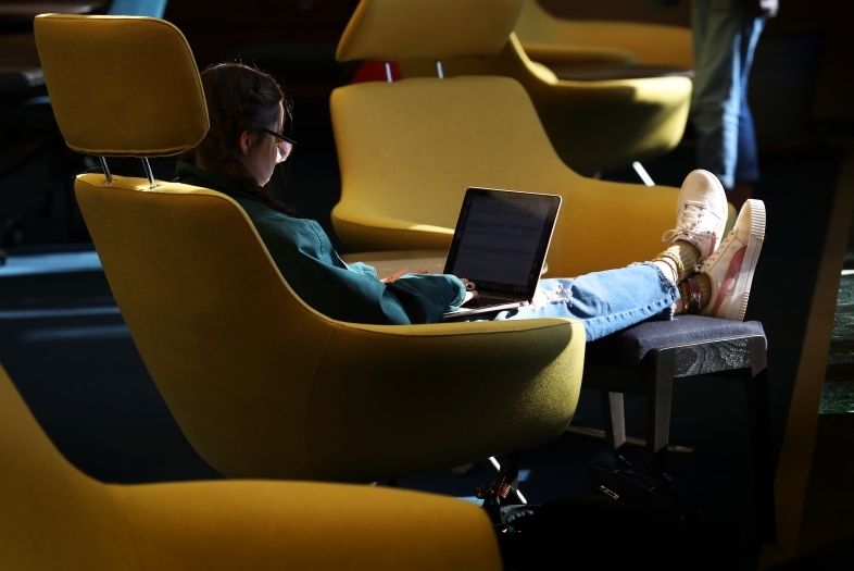 Student Studying in Library on Laptop