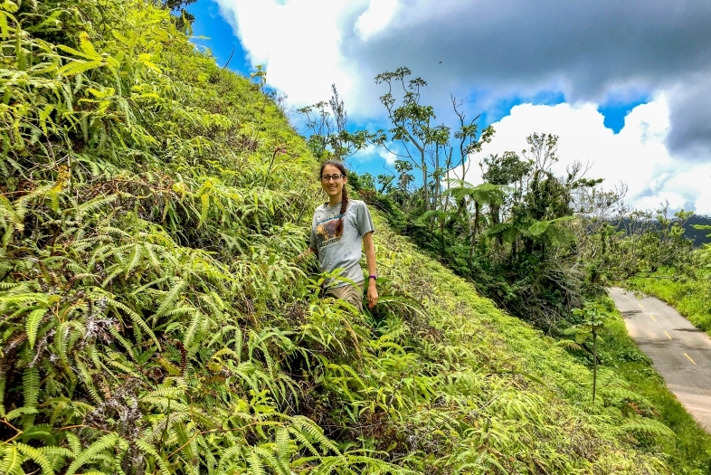 Lydia Soifer stands on a hill covered in vegetation