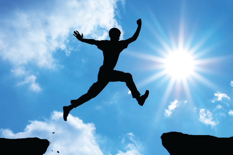 Person jumping between cliff ends