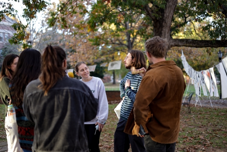 Students in a group outside, surrounded by papers on clotheslines