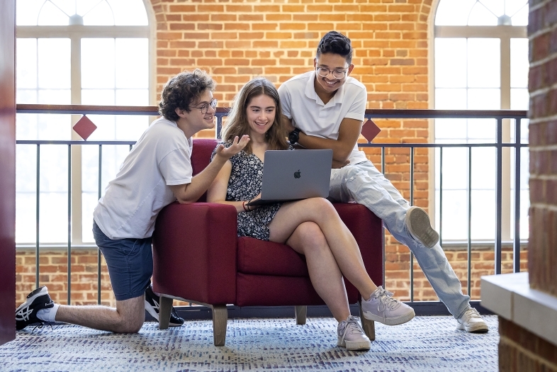 Group of students around laptop