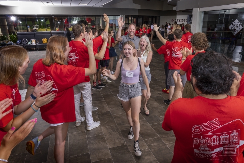 student and family walking through welcome tunnel during Orientation