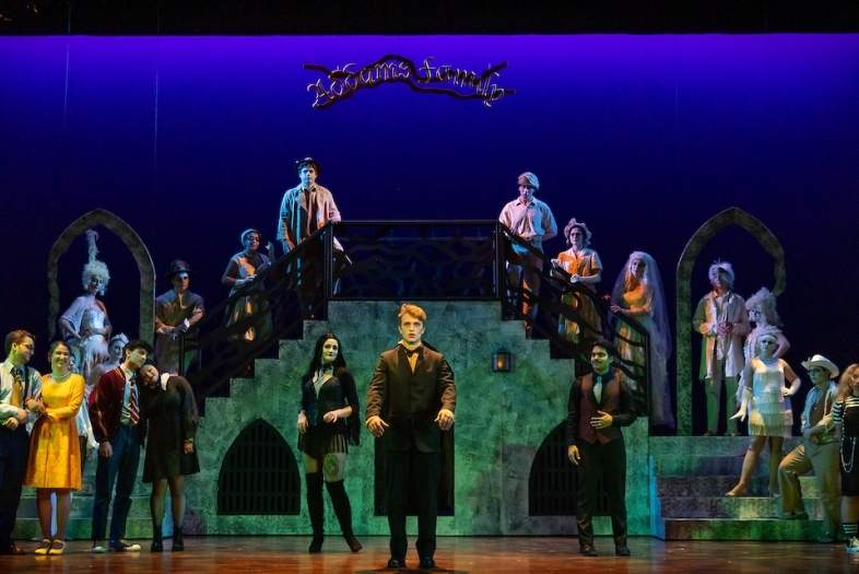 students onstage wearing Addams Family costumes