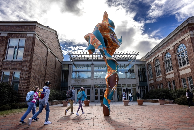 Spring day in front of the Wall Building with Shonibare sculpture and students in the foreground