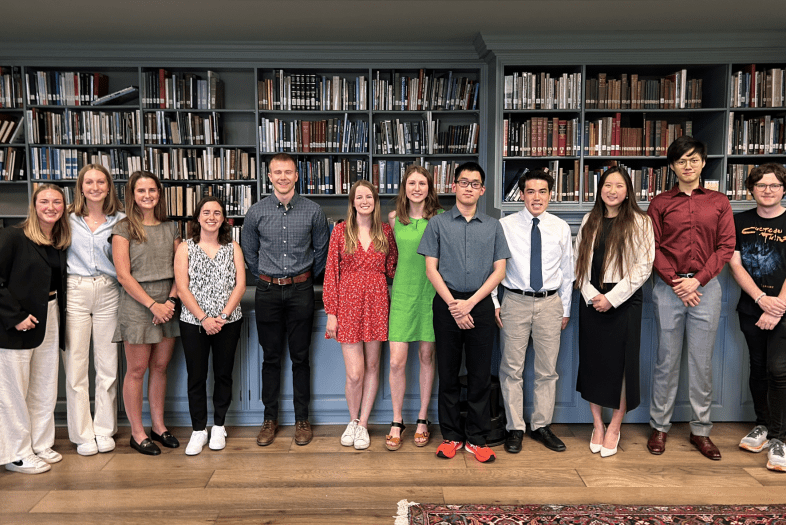 A group of students in front of a bookcase