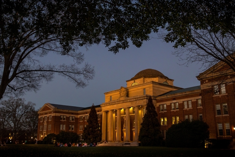 Chambers Building at sunset with a group of students on the front lawn