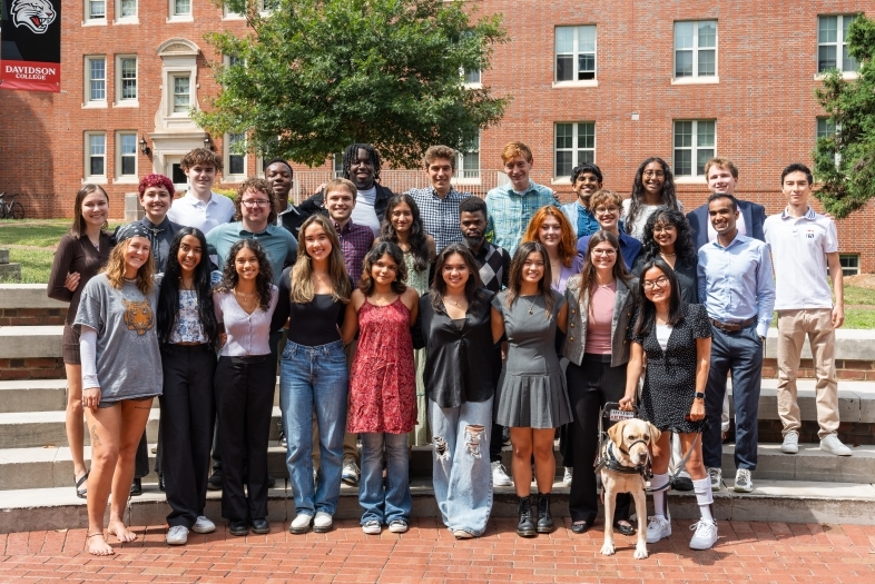 a group of young people standing together on a brick staircase outside