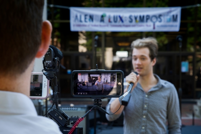 Someone recording a speaker at Alenda Lux Symposium