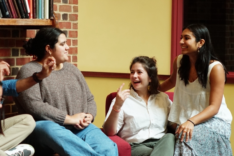 a group of students sit together laughing and talking