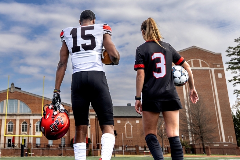 Davidson football player and soccer player walking away together on field