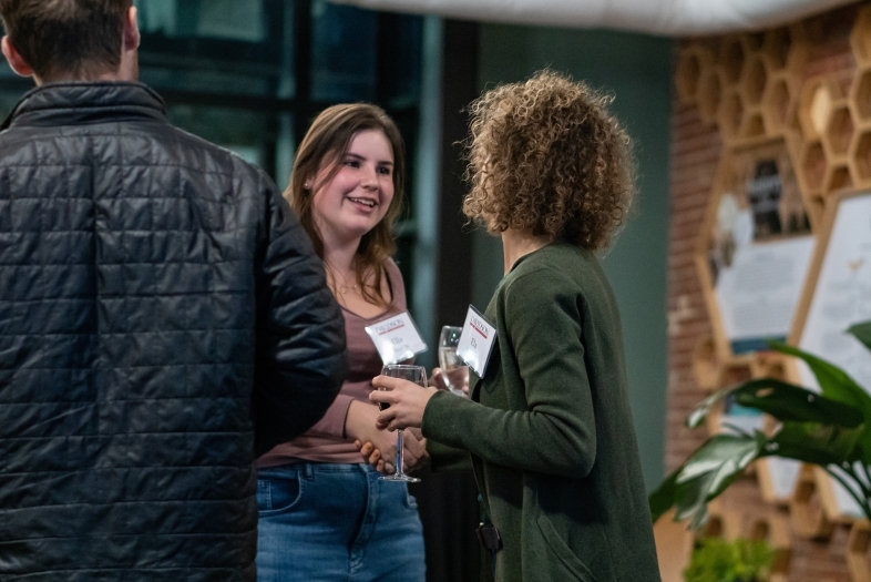 a young woman shakes the hand of an older woman in an office space