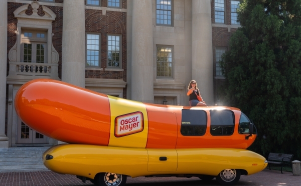 Emily Schmidtt '23 sits atop the Weinermobile in front of the Chambers Building