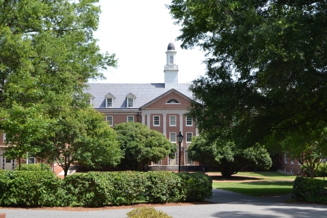 Belk Residence Hall seen through trees and bushes