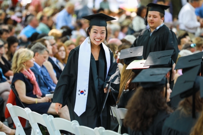 Student Smiles with diploma