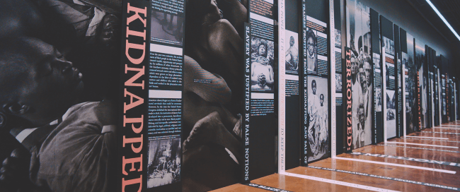 EJI Museum Exhbit with black and white photos of enslaved persons, the word Kidnapped at the front