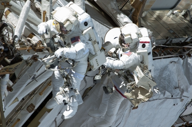 Chris Cassidy (right) and Tom Marshburn complete a space walk to inspect and replace a pump controller box leaking ammonia coolant on the International Space Station