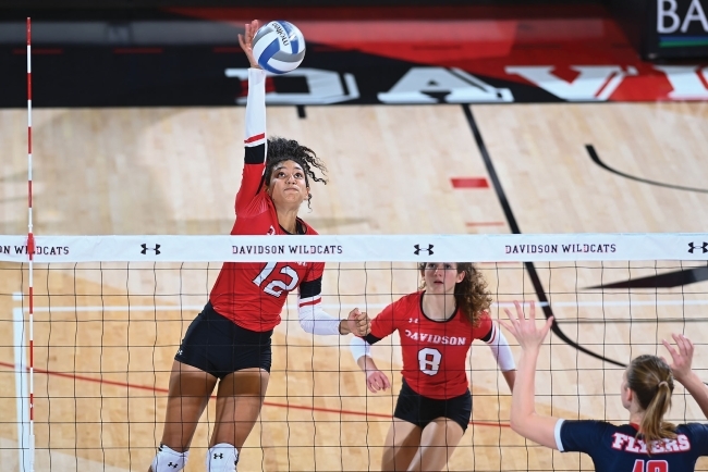 Volleyball Players Hitting Ball Over Net