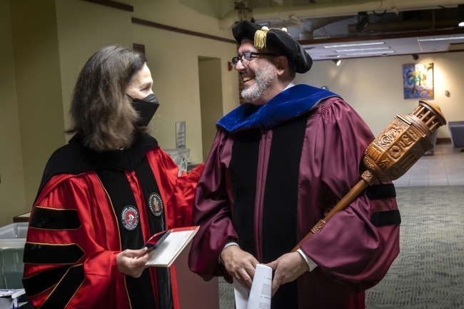 Carol and faculty member smiling together outside Duke Hall in Union