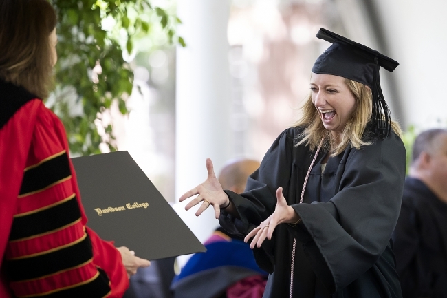 Class of 2020 Commencement excited grad receiving diploma from Carol Quillen