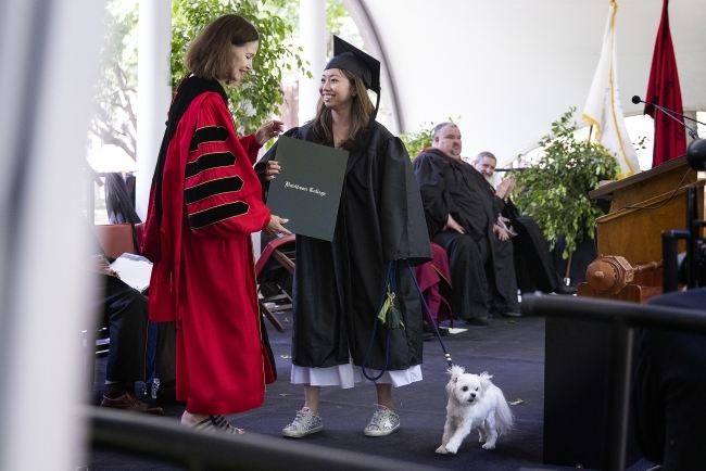 President Carol Quillen hands diploma to student on stage