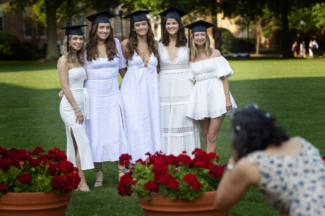 group of graduates with caps on smile for camera 