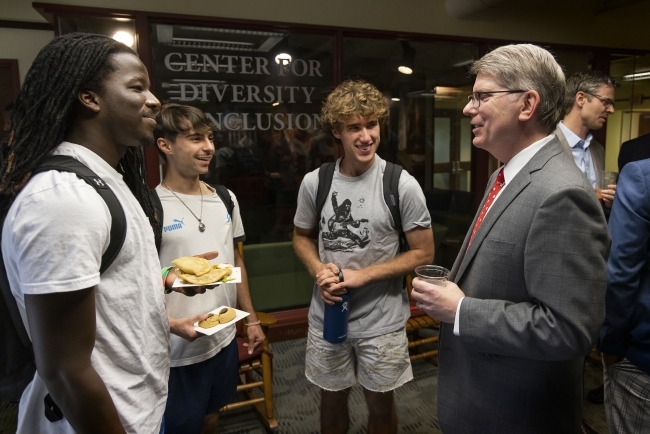 President Doug Hicks conversing with students