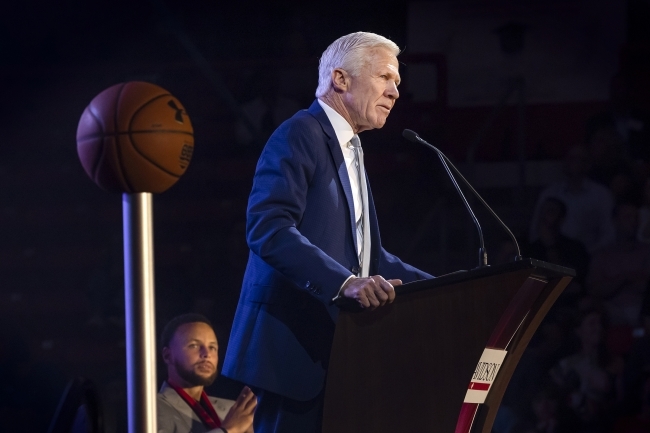 Steph Curry looks on as Coach McKillop speaks during Curry for 3 Event