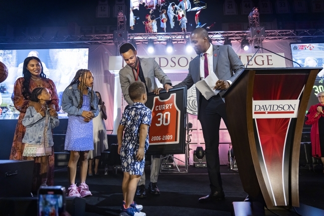 Chris Clunie presents Steph Curry and family a framed 30 jersey during the Steph for 3 Event