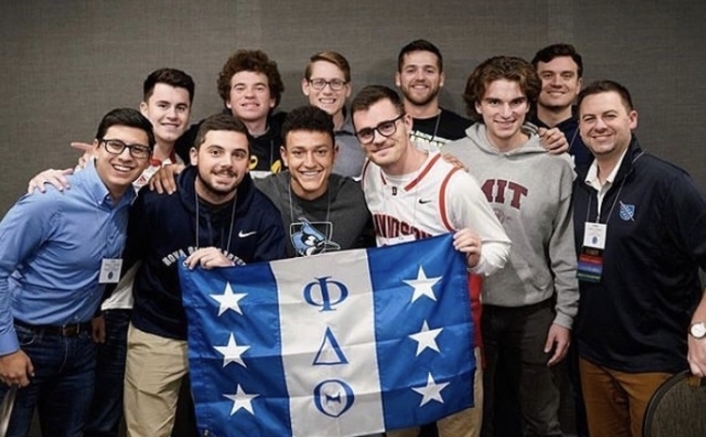 Men holding Phi Delta Theta fraternity flag