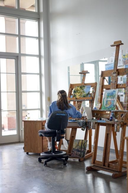 Student painting in art studio
