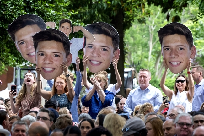 Family holds fat heads of son in graduation crowd