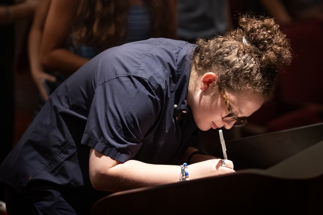 student signs Honor Code in auditorium