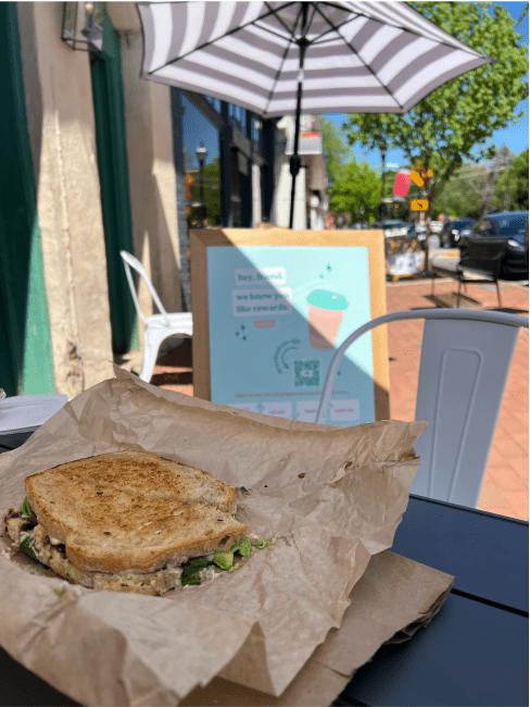 a sandwich in a brown paper wrapper on a table