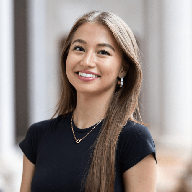 a young Asian woman wearing a black top and smiling