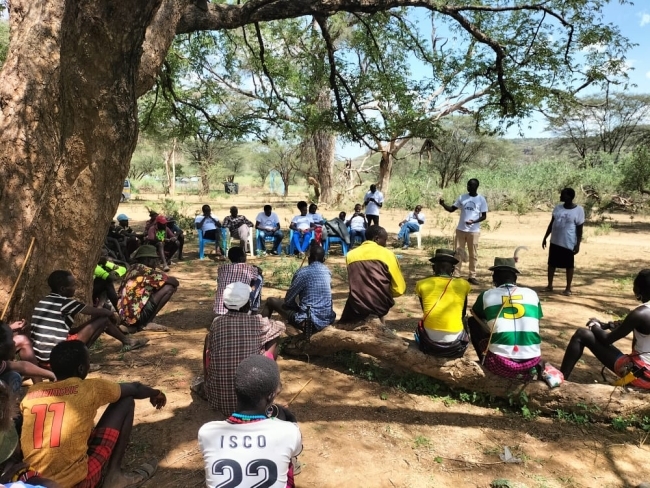 a group of people sitting together in the outdoors