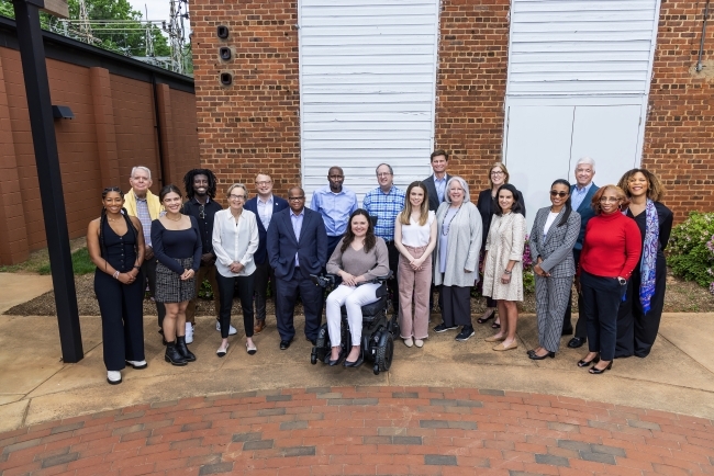 a group of people standing together in front of a brick building