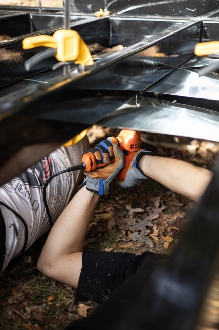 Students under trailer doing construction