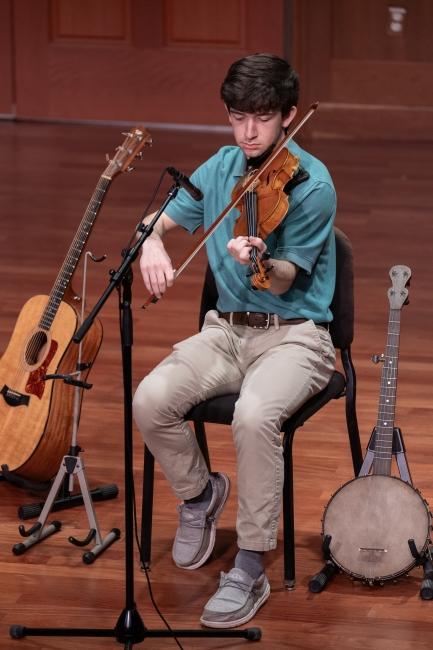 a young man playing in the Appalachian ensemble on stage
