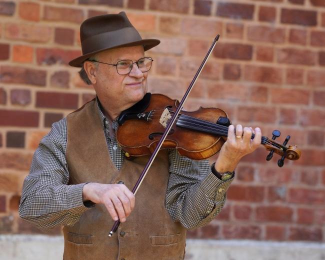 a middle aged man plays the violin