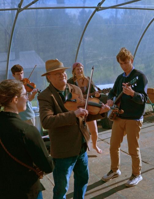 a group of people playing instruments in a greenhouse