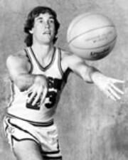 a young white man throws a basketball while wearing a Davidson College uniform