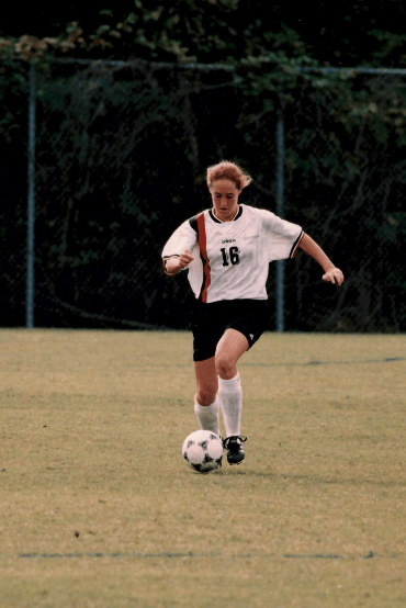 a young woman playing soccer in a Davidson College uniform