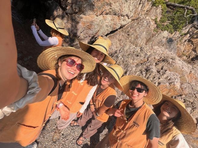 a group of students in straw hats smiling together